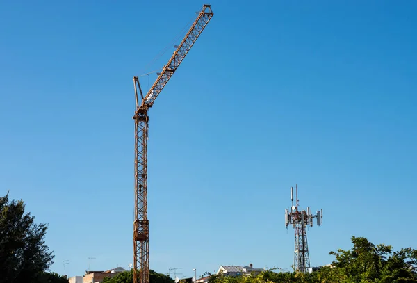 Pomarańczowy Żuraw Budowlany Wieżą Telekomunikacyjną Lub Anteny Zielonym Parku Miejskim — Zdjęcie stockowe