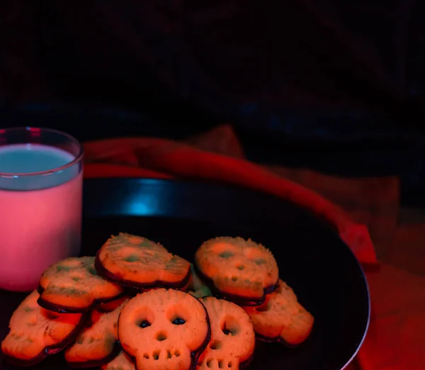Bir bardak sütlü cadılar bayramı kafatası kurabiyeleri - siyah arkaplan fotokopi alanı - korku hali