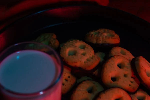 Bir bardak sütlü cadılar bayramı kafatası kurabiyeleri - siyah arkaplan fotokopi alanı - korku hali