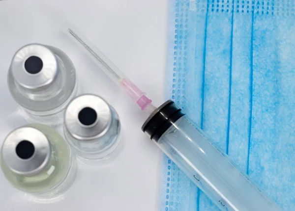 Coronavirus COVID-19 Aşı Şişesi, Şırınga ve Mavi Maske beyaz arka planda - kopyalama alanını kapat