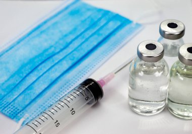 Coronavirus COVID-19 Aşı Şişesi, Şırınga ve Mavi Maske beyaz arka planda - kopyalama alanını kapat