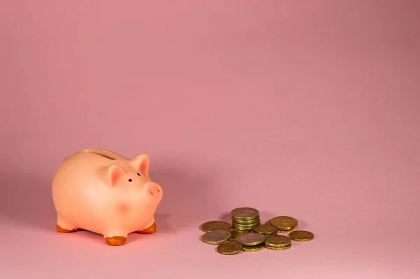 Close Van Roze Piggy Bank Met Munten Tegen Roze Achtergrond — Stockfoto