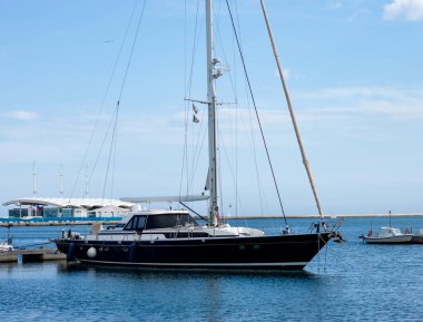 Mavi gökyüzüyle güneşli bir günde Akdeniz 'de bir rıhtımda yan manzara teknesi,