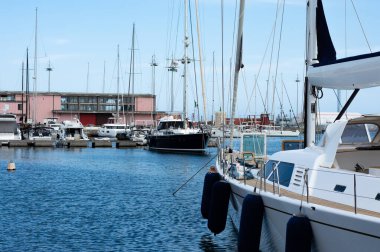 Mavi gökyüzüyle güneşli bir günde Akdeniz 'de bir rıhtımda yan manzara tekneleri,