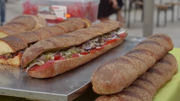 大きな長いサンドイッチバゲット トマトでいっぱいイタリアのパン 玉ねぎとジャガイモ ストリートフードイベント — ストック動画