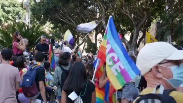 Kalabalık aseksüellik, biseksüellik ve panseksüellik hakkında çok renkli bayraklar sallıyor. — Stok video