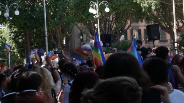 Multitud ondea banderas de arco iris en el uso de máscaras médicas — Vídeos de Stock