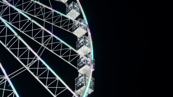 La ruota panoramica di notte in movimento e alcuni uccelli volano sullo sfondo in uno stormo — Video Stock