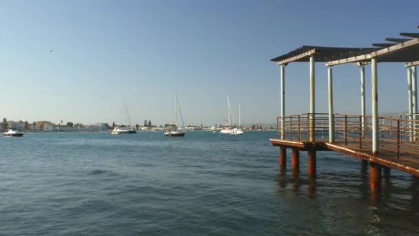 Pequeño muelle en el mar con gaviotas volando y barcos a — Vídeo de stock