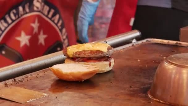Preparar un sándwich con hamburguesa, queso, lechuga, tomate y salsas — Vídeos de Stock