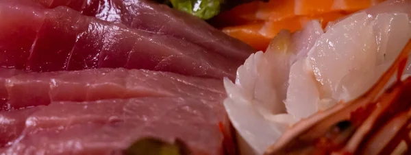 Afiş makrosu çeşitli çiğ balık, ton balığı ve somon dilimlerini kapatır. saşimi