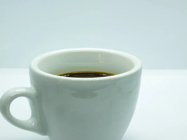 Beyaz arkaplanda küçük beyaz kahve fincanını kapat, boşluğu kopyala