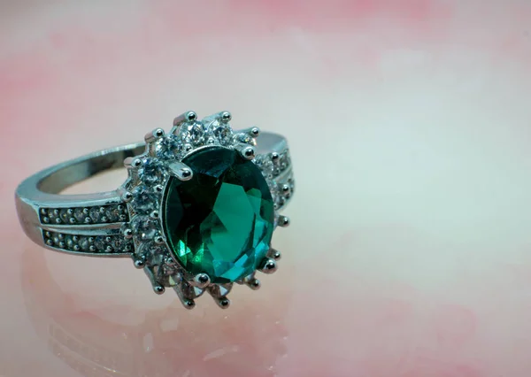 Değerli taşlı değerli yüzük, zümrüt mücevher seti. Pembe mermer arka plan kopyalama alanı boş