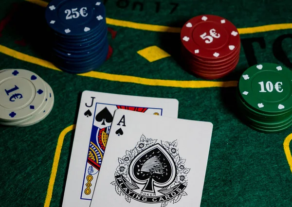cards with ace and jack of spades, scoring with black jack hand at the gaming table with chips