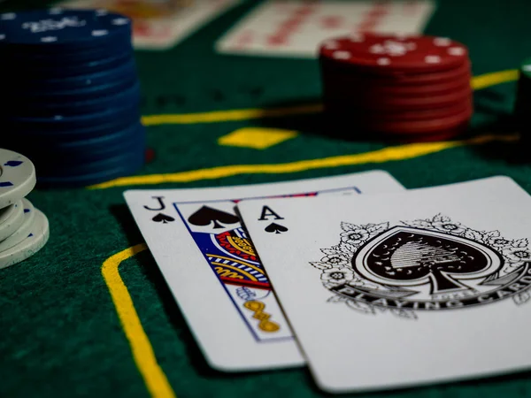 cards with ace and jack of spades, scoring with black jack hand at the gaming table with chips low angle perspective