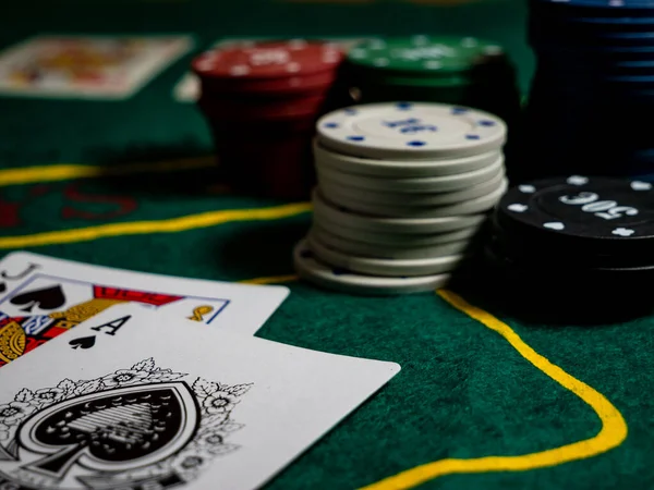 cards with ace and jack of spades, scoring with black jack hand at the gaming table with chips low angle perspective