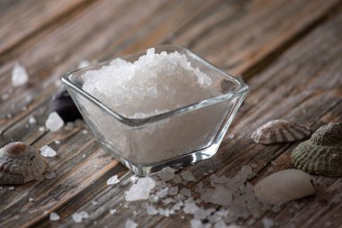 Tahta tezgahta cam bir kasede deniz tuzu.