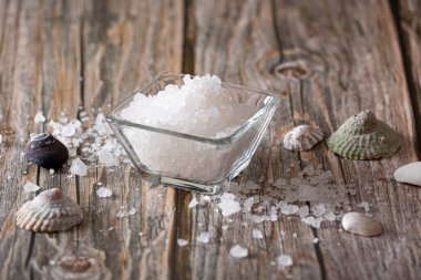 Tahta tezgahta cam bir kasede deniz tuzu.
