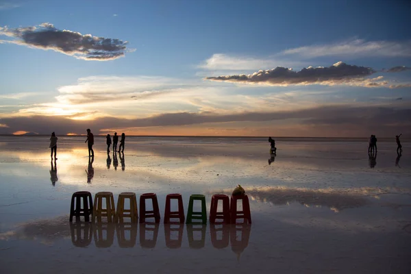 İnsanlar Salar de Uyuni, Bolivya 'da günbatımının tadını çıkarıyorlar.