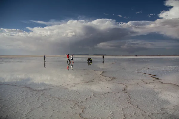 İnsanlar Salar de Uyuni, Bolivya 'da günbatımının tadını çıkarıyorlar.