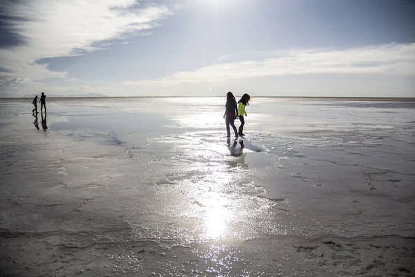 İnsanlar Salar de Uyuni, Bolivya 'da günbatımının tadını çıkarıyorlar.