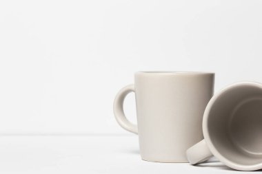 İki beyaz seramik espresso fincanı beyaz arka plandaki kafe sanatına karşı.. 