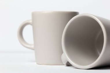 İki beyaz seramik espresso fincanı beyaz arka plandaki kafe sanatına karşı.. 