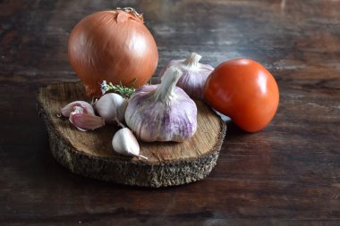 Pişirmek için taze malzemeler: domates ve baharatlar ahşap masa arkasında.