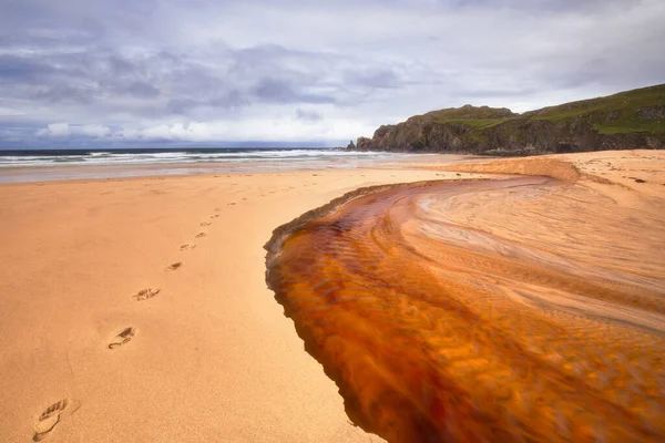 O rio vermelho desce até Dalmore Beach, na Ilha de Lewis — Fotografia de Stock
