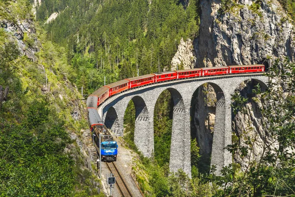 Landwasser Viaduct em Filisur, Suíça. É o marco famoso de suíço. Trem expresso vermelho na ponte alta nas montanhas. Vista panorâmica da incrível ferrovia no verão. Conceito de viagem em Alpine Europe. — Fotografia de Stock