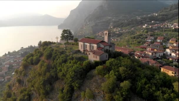 Vista panorâmica aérea bonita do drone ao lago de Iseo com a igreja no alto da colina, Lombardia, Itália — Vídeo de Stock