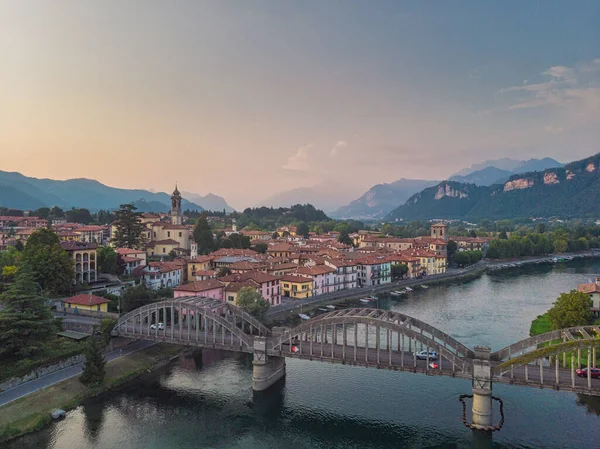 Letecký pohled na roztomilé malé italské vesničky na březích modré řeky s mostem v popředí, Itálie — Stock fotografie