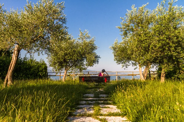 Женщина сидит на скамейке — стоковое фото