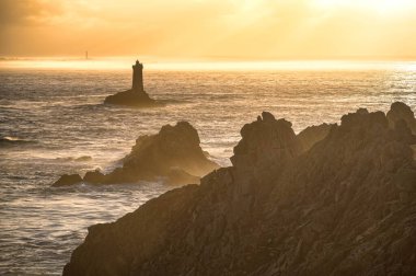 Pointe du Raz 'ın kayalık uçurumlarında gün batımı Atlantik Okyanusu dalgaları, Finistere, Brittany, Fransa.