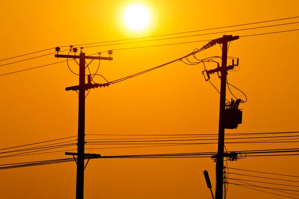 Silhueta de linhas eléctricas pólo eléctrico e fios ao pôr do sol — Fotografia de Stock