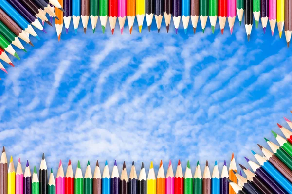 Ram av färg pennor på blå himmel bakgrund — Stockfoto