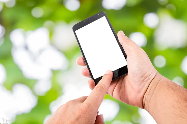 Adam elini boş dokunmatik ekran akıllı telefon üzerinde yumuşak yeşil natur