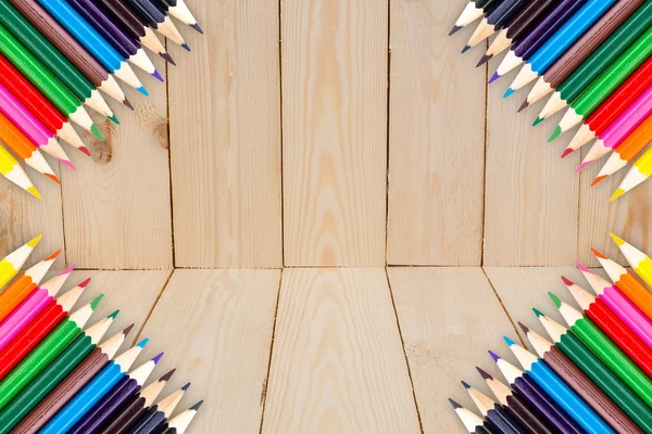 Ram av färg pennor på trä textur bakgrund — Stockfoto