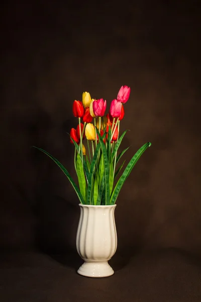 Rött och gult och rosa tulpaner blomma i kruka på vintage ba Royaltyfria Stockfoton