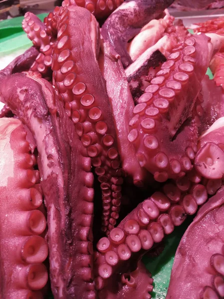 Deniz ürünleri pazarındaki kırmızı ahtapot dokunaçlarına yakın çekim.