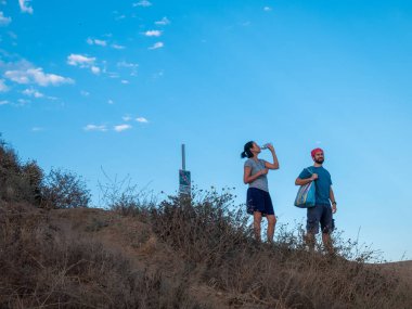 LOS ANGELES, ABD - 28 Haziran 2016: Yolculuğun zirvesinde su alan yürüyüş yapan çiftin görüntüsü.