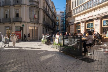Malaga, İspanya - 23 Şubat 2021: Salgın sırasında Malaga 'nın tarihi merkezinde yürüyen insanların görüntüsü.