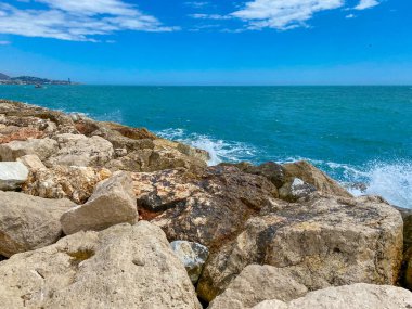 Yazın Malaga Akdeniz 'deki kayalıklara ulaşan deniz manzarası.