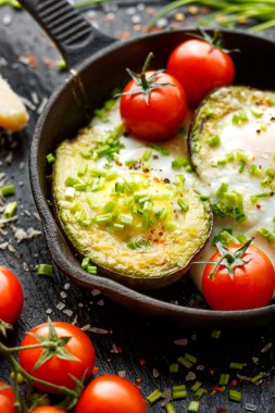 Avocado baked with egg, parmesan cheese and chives