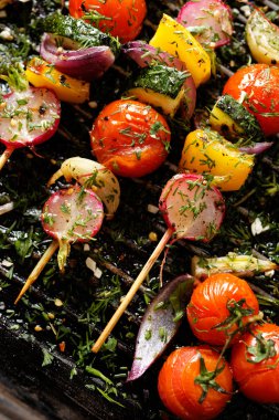 Izgara sebzeli şiş kiraz domates, turp, biber ve soğan ile bir ızgara tava üzerinde taze dereotu