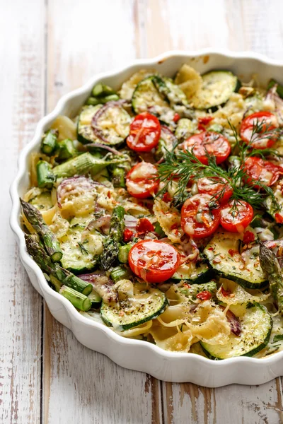 Cazuela vegetariana con pasta, calabacín, tomates cherry, espárragos y cebollas — Foto de Stock