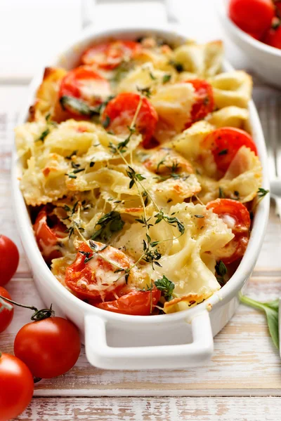 Delicioso plato vegetariano, cazuela con pasta farfalle, tomate cherry, queso mozzarella y hierbas — Foto de Stock