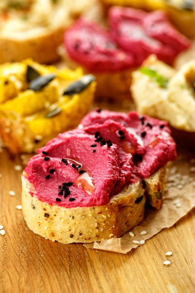 Sandwich with hummus with roasted beets sprinkled with nigella seeds — Stock Photo, Image