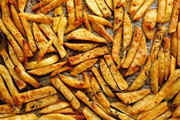 Batatas fritas com ervas de adição — Fotografia de Stock