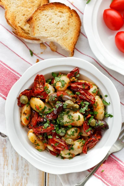 Ensalada de frijoles blancos con adición de tomates secos, aceitunas, alcaparras y perejil fresco — Foto de Stock